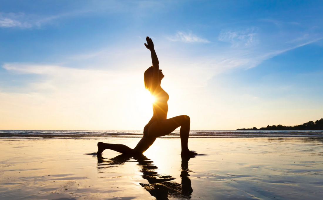 Woman practicing yoga on a beach supporting autophagy and overall cellular health.
